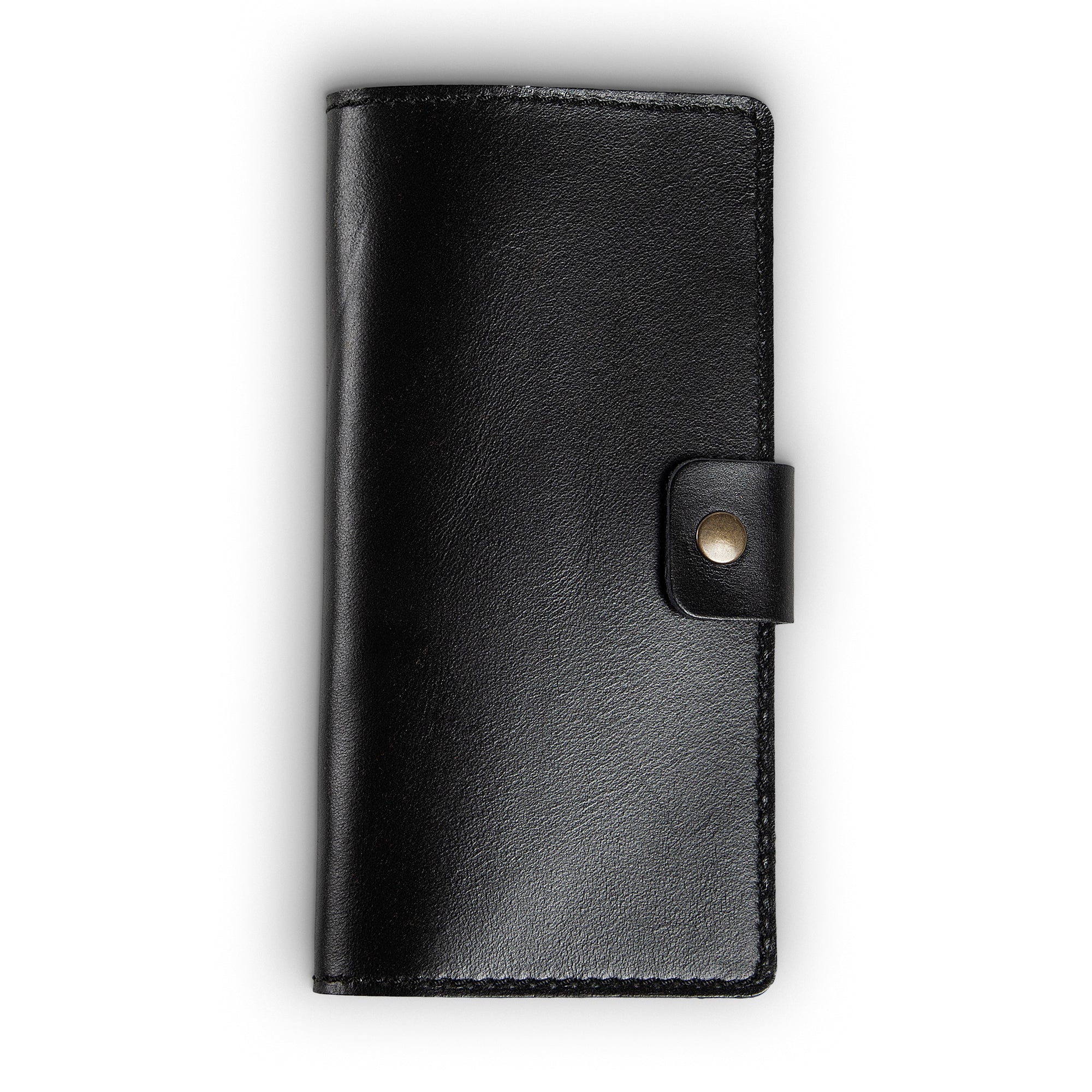 Clark Leather Checkbook Cover in Dexios Black, closed and laid flat on a white surface. Premium top-grain Dexios calfskin in a deep glossy black with smooth pull-up surface sheen and subtle natural grain variation. No visible exterior stitching on this colorway. A small leather tab with an antique brass snap closure sits centered on the right edge.