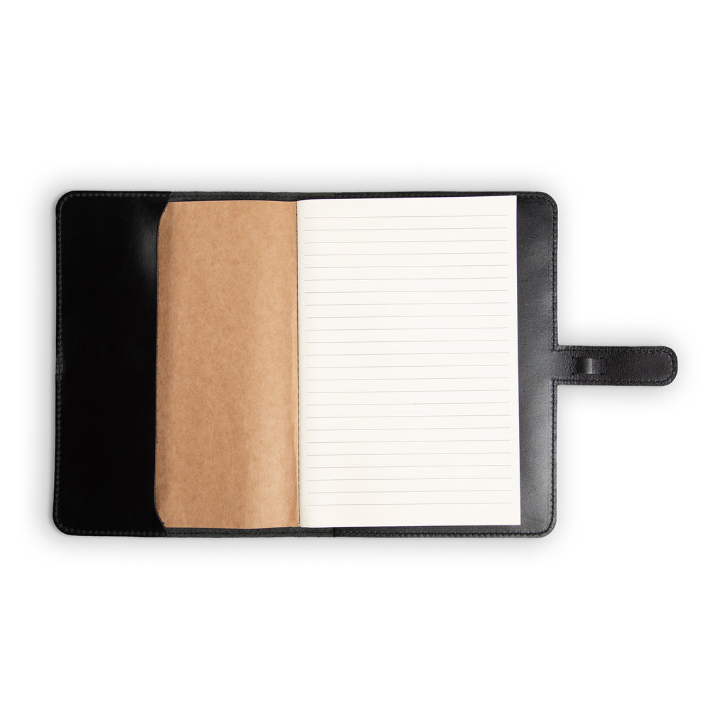 DuPage Black journal open to show lined paper refill on right and natural vachetta leather slip pocket on left, inside black Dexios calfskin cover with black perimeter stitching. 