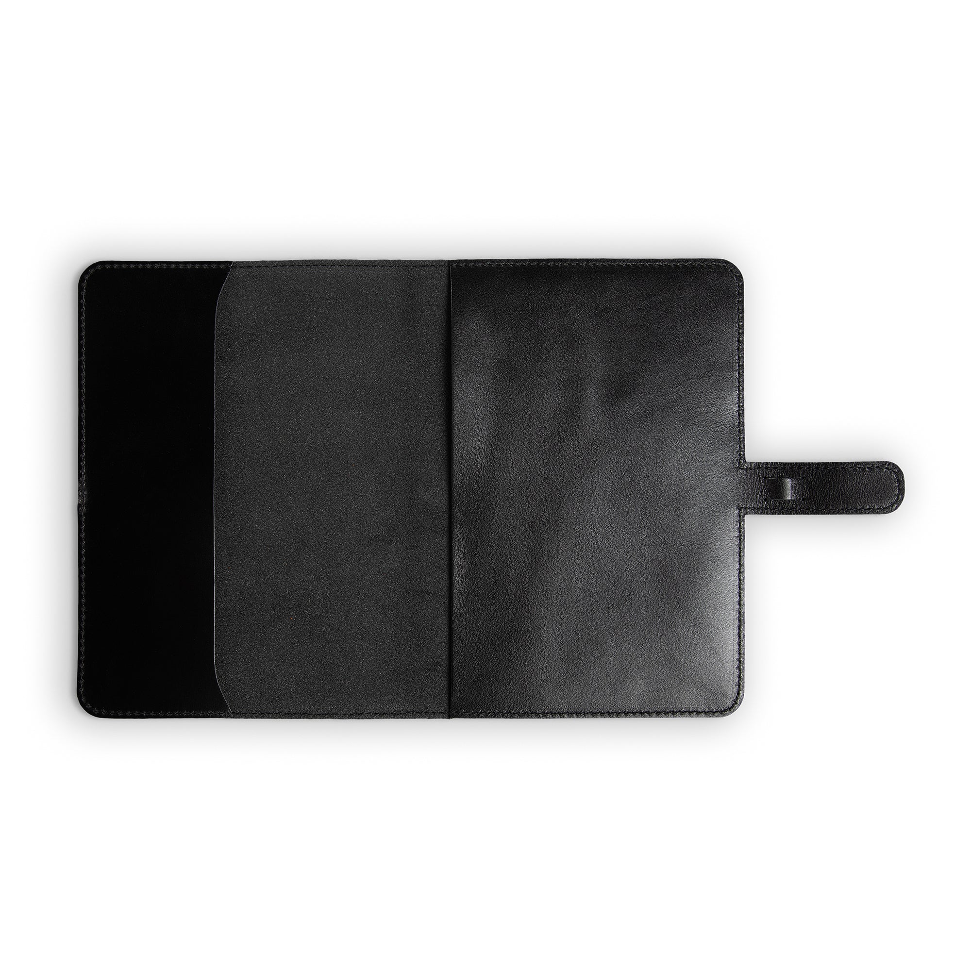 Interior of black DuPage leather journal fully open and empty, showing pull-up Dexios calfskin lining on both panels, slip pocket on left, black stitching, and strap tab on right.