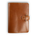 Mustard brown Dexios pull-up calfskin leather journal, front cover view, showing warm honey-tan smooth surface with subtle natural variation, orange saddle stitching, and antique brass rivet strap closure.