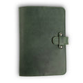 Forest green Dallas Crazy Horse leather journal, front cover view, showing waxy pull-up surface with natural tonal variation, green saddle stitching, and antique brass rivet strap closure on right side.