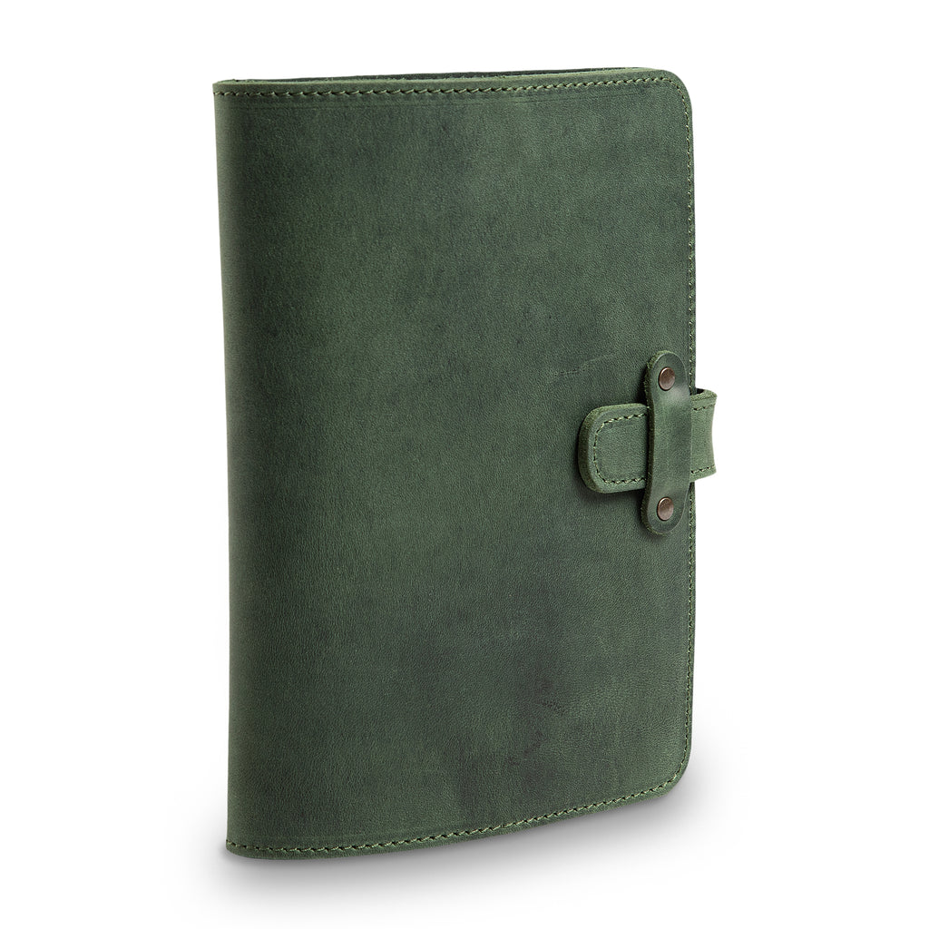 Three-quarter angled view of closed forest green DuPage journal highlighting the leather strap closure with antique brass rivets, green stitching, and waxy Dallas Crazy Horse surface.