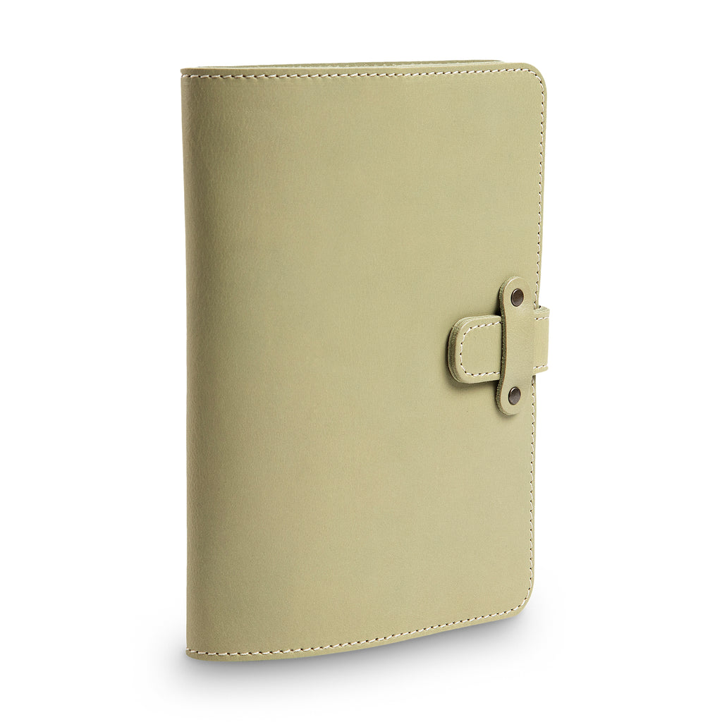 Three-quarter angled view of closed aqua green DuPage leather journal highlighting the leather strap closure with antique brass rivets, cream stitching, and smooth Iphitos buffalo surface.