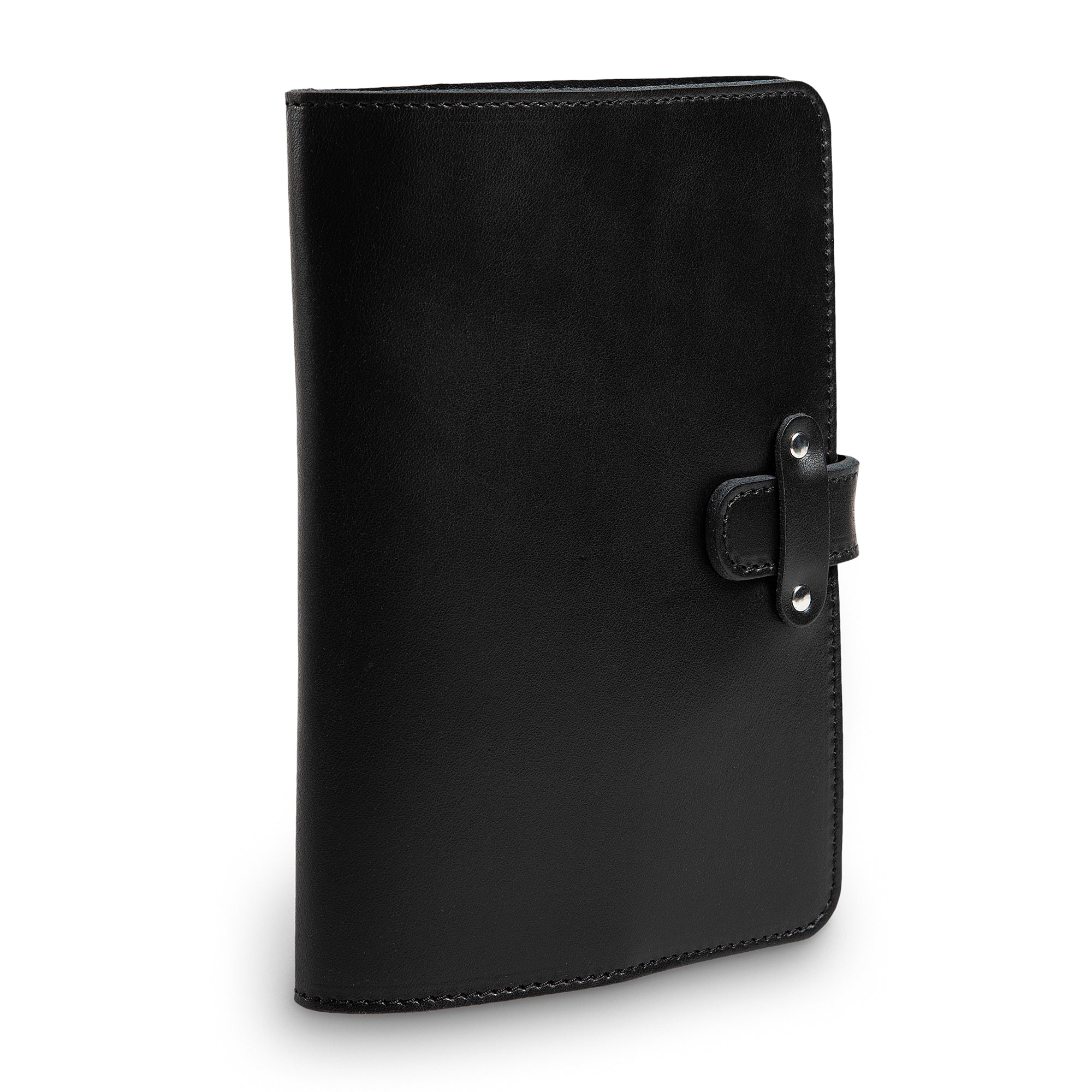 Three-quarter angled view of closed black DuPage leather journal highlighting the leather strap closure with silver-tone rivets, black stitching, and smooth Dexios calfskin surface.