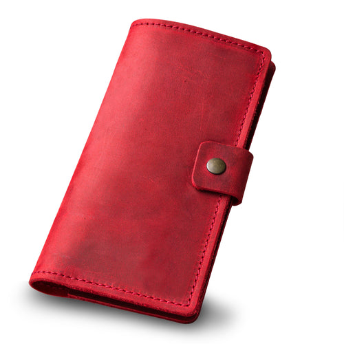 Angled view of the rose red leather checkbook cover, closed. Shows full depth and construction, hand-stitched perimeter in red thread, and antique brass snap tab. Waxy crazy horse surface with natural color variation and soft sheen visible across the panel.