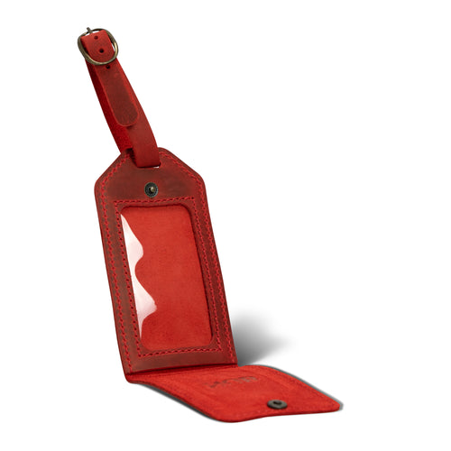Open red leather luggage tag with clear identification window and suede-lined interior