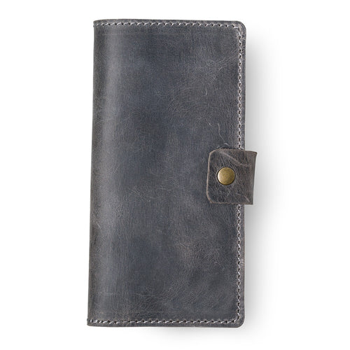 Rock gray full-grain leather checkbook cover, closed and laid flat. Matte waxy surface with natural scratch marks and tonal variation across the hide. Hand-stitched edges in light gray thread with an antique brass snap closure tab on the right side.