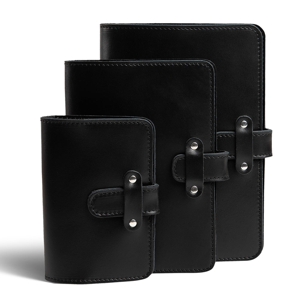 Three DuPage leather journals in black displayed together showing Pocket, Midi, and Full size comparison, all with matching black stitching and silver-tone rivet strap closures. 