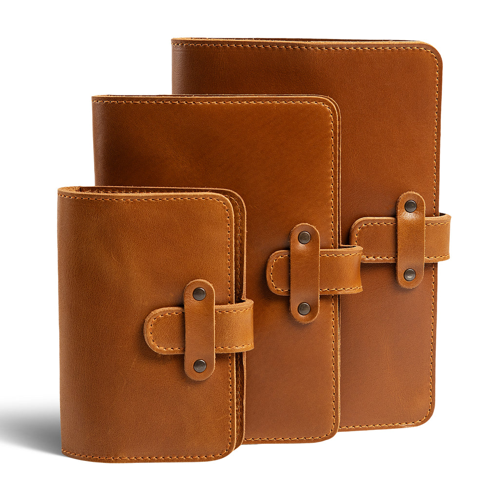 Three DuPage leather journals in mustard brown showing Pocket, Midi, and Full size comparison, all with matching orange saddle stitching, antique brass rivets, and smooth warm tan pull-up surfaces.
