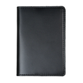 Dual tone black leather passport cover, closed and laid flat. Smooth glossy pull-up surface with subtle tonal variation revealing deep charcoal and near-black blending. Hand-stitched edges in matching black thread. Rounded corners and clean minimal silhouette.