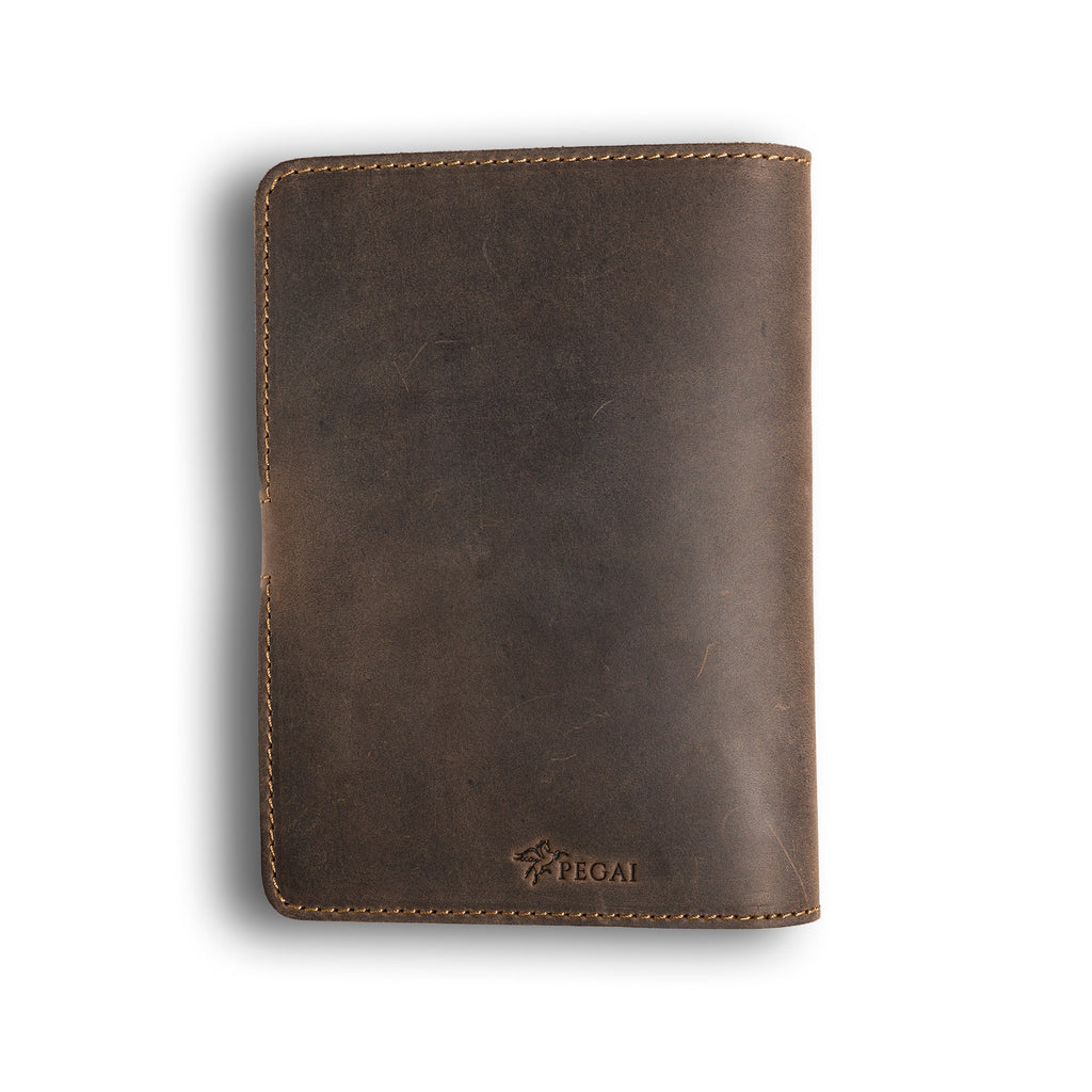 Back cover of chestnut brown DuPage Dallas Crazy Horse leather journal showing distressed pull-up surface with natural tonal variation, tan saddle stitching, and embossed PEGAI logo at bottom center. 