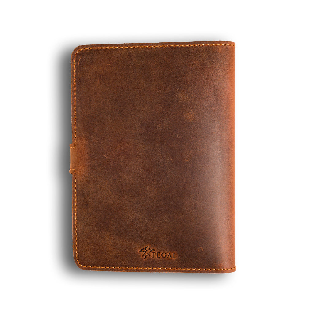 Back cover of mahogany DuPage Dallas Crazy Horse leather journal showing richly distressed warm brown pull-up surface, orange perimeter stitching, side strap tab, and embossed PEGAI logo at bottom center.