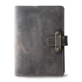 Rock gray Dallas Crazy Horse leather journal, front cover view, showing heavily distressed cool gray waxy pull-up surface with natural tonal variation, gray saddle stitching, and antique brass rivet strap closure. 