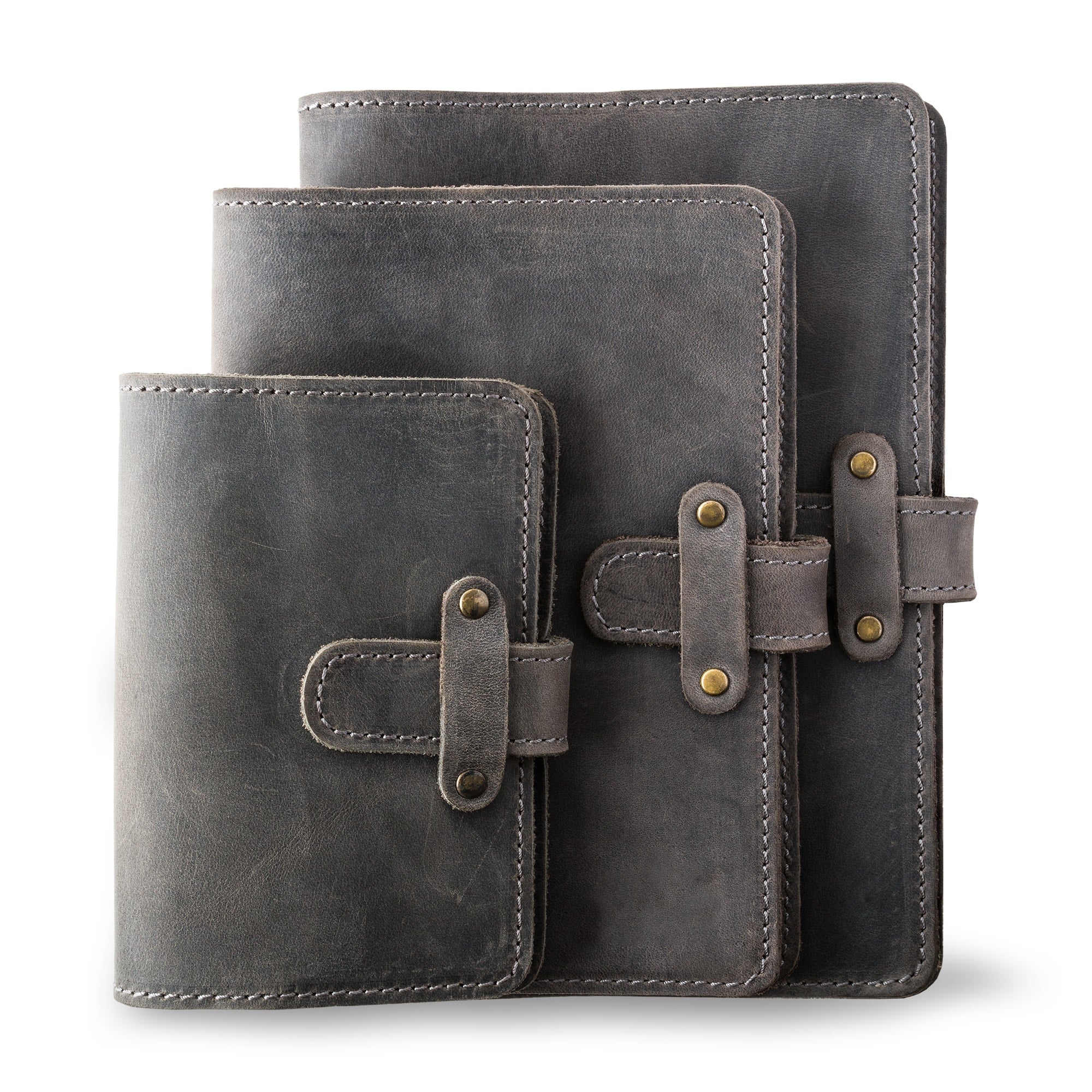 Three DuPage leather journals in rock gray showing Pocket, Midi, and Full size comparison, all with matching gray saddle stitching, antique brass rivets, and heavily distressed cool gray pull-up surfaces. 