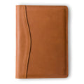 PEGAI Eriksen Jr. padfolio in cognac brown Zurich pull-up calfskin, closed, showing curved seam detail along the spine and natural aniline sheen across the cover. 