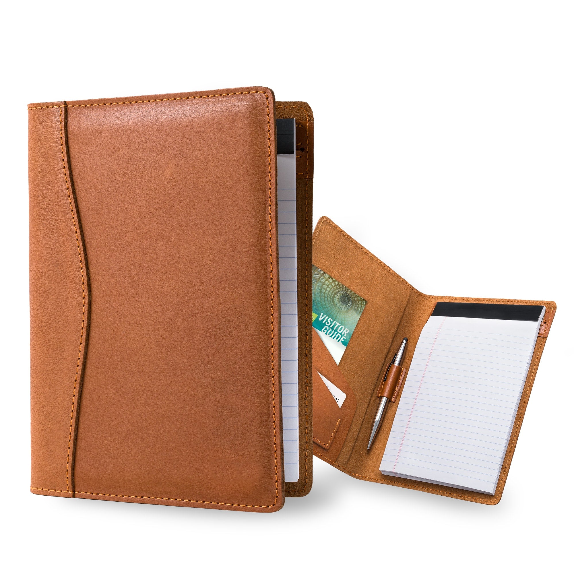 Two PEGAI Eriksen Jr. padfolios in cognac brown Zurich calfskin, one standing closed with a legal pad inside, the other open showing a visitor guide, cards, pen, and notepad. 