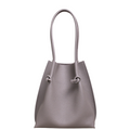 Flora Everyday Leather Tote in Togo Calf Gris, front view on white background. Structured bucket-style tote with tall rolled leather handles and two knotted leather ties cinching the open top.