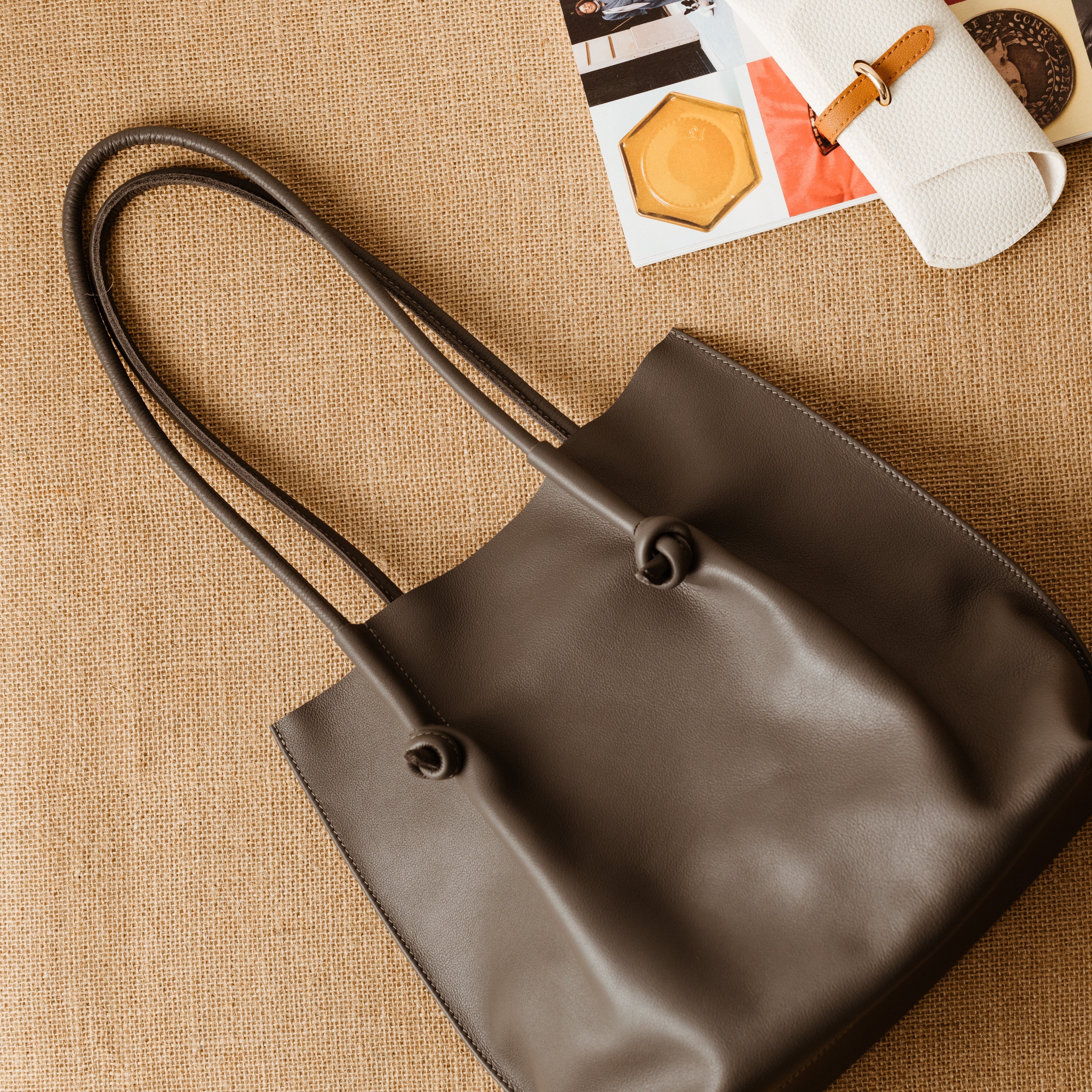Flora Leather Tote in Silky Calf Gray with raw suede interior, rolled handles, and folded edge detailing—crafted for everyday ease and timeless charm.