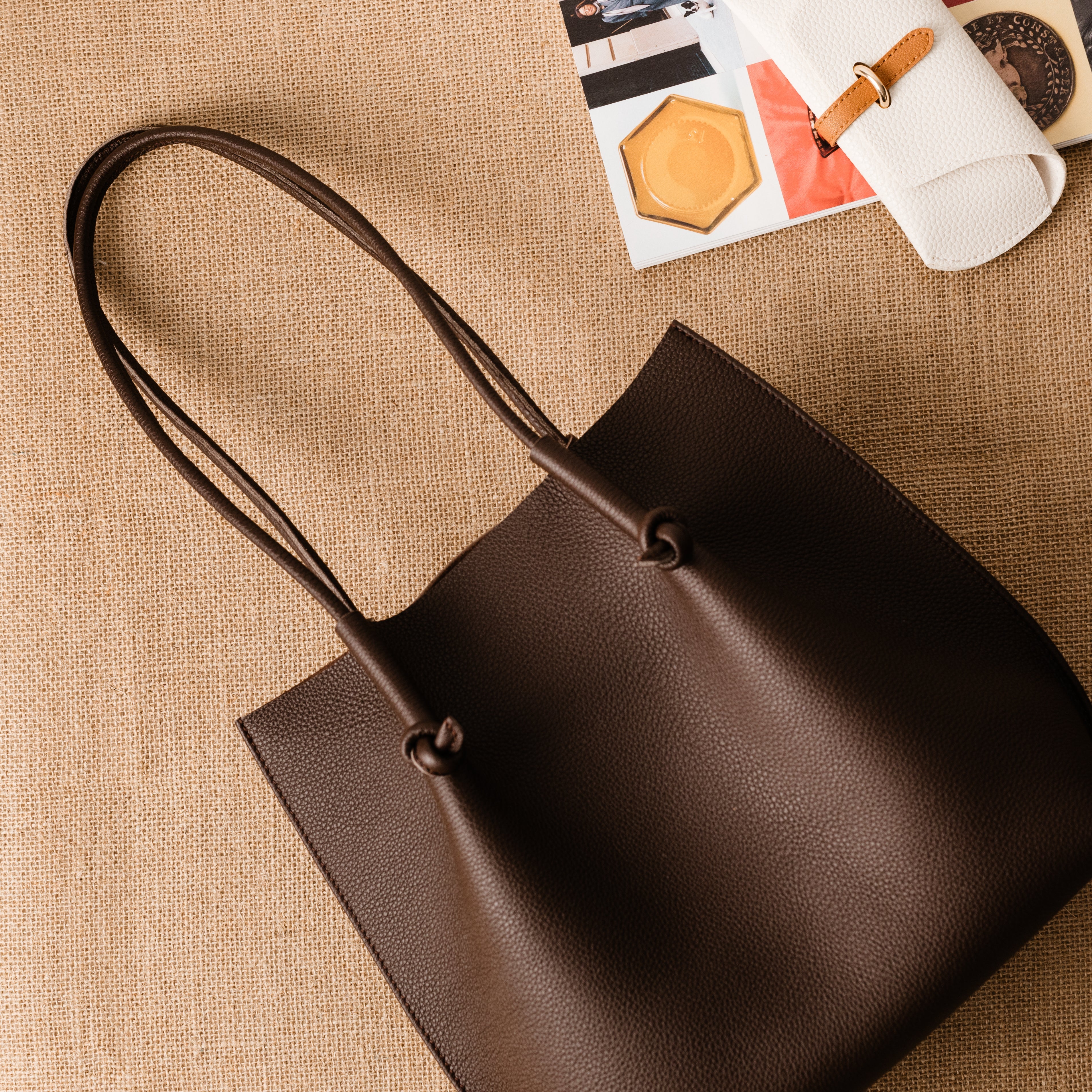 Flora Everyday Leather Tote in Togo Calf Brown with raw suede interior, rolled handles, and folded edge details—crafted for timeless, daily use.