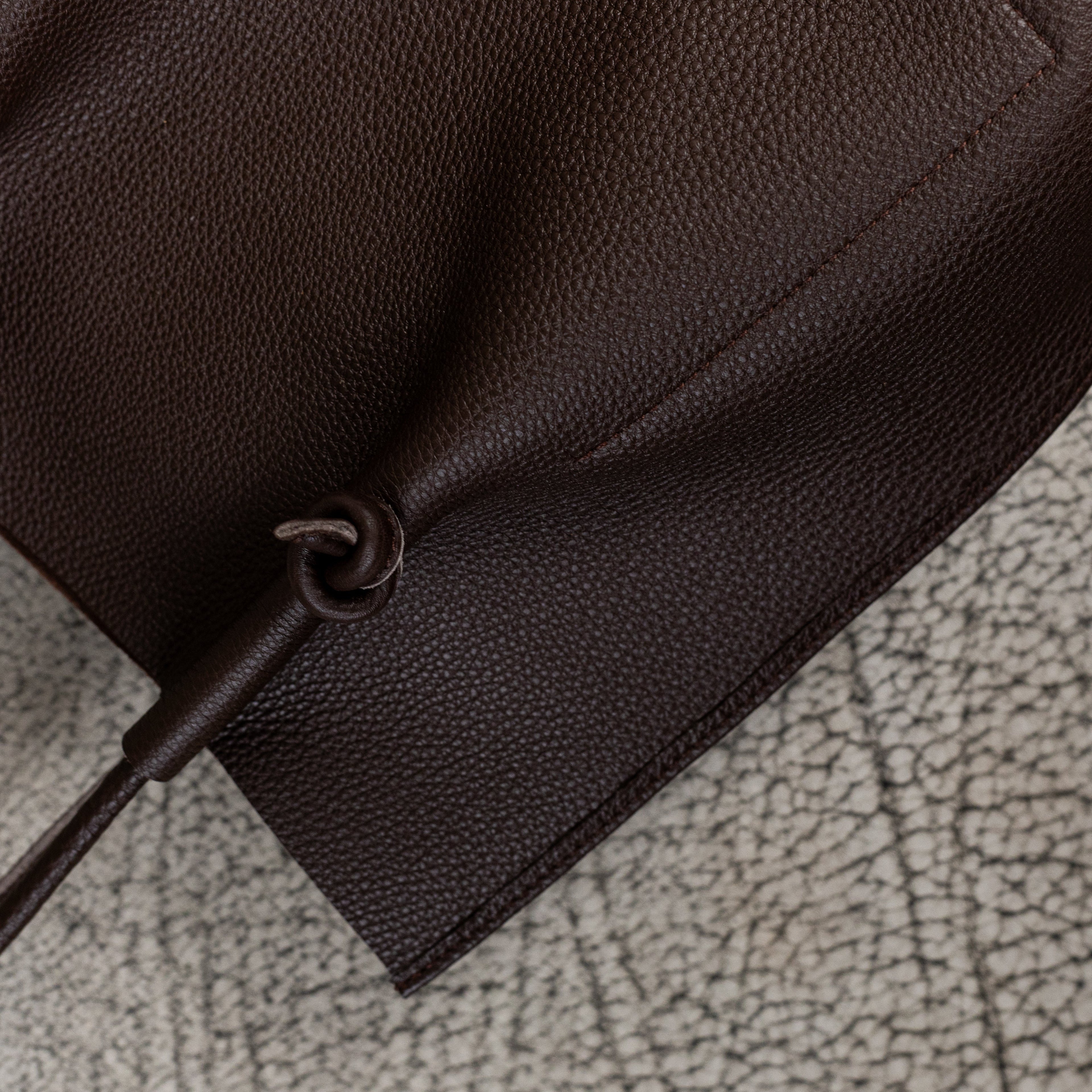 Flora Everyday Leather Tote in Togo Calf Brown with raw suede interior, rolled handles, and folded edge details—crafted for timeless, daily use.