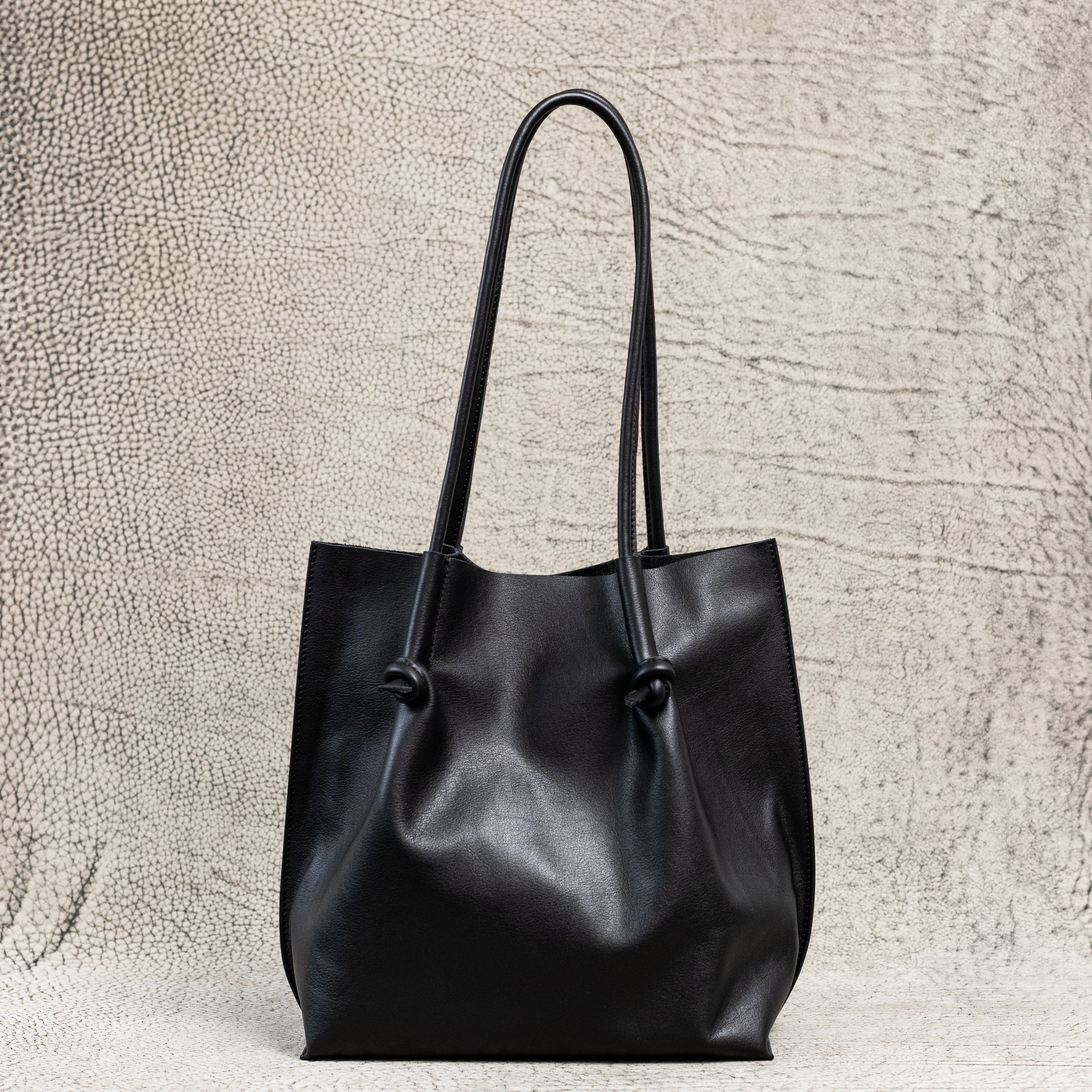 Flora Everyday Leather Tote in Smooth Calf Black with suede interior, rolled handles, and hand-finished edges—crafted for everyday elegance and ease.