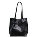 Flora Everyday Tote in Smooth Calf Black stands upright with a soft, fine-grain finish, dual rolled handles, and a single knotted leather closure on each side.