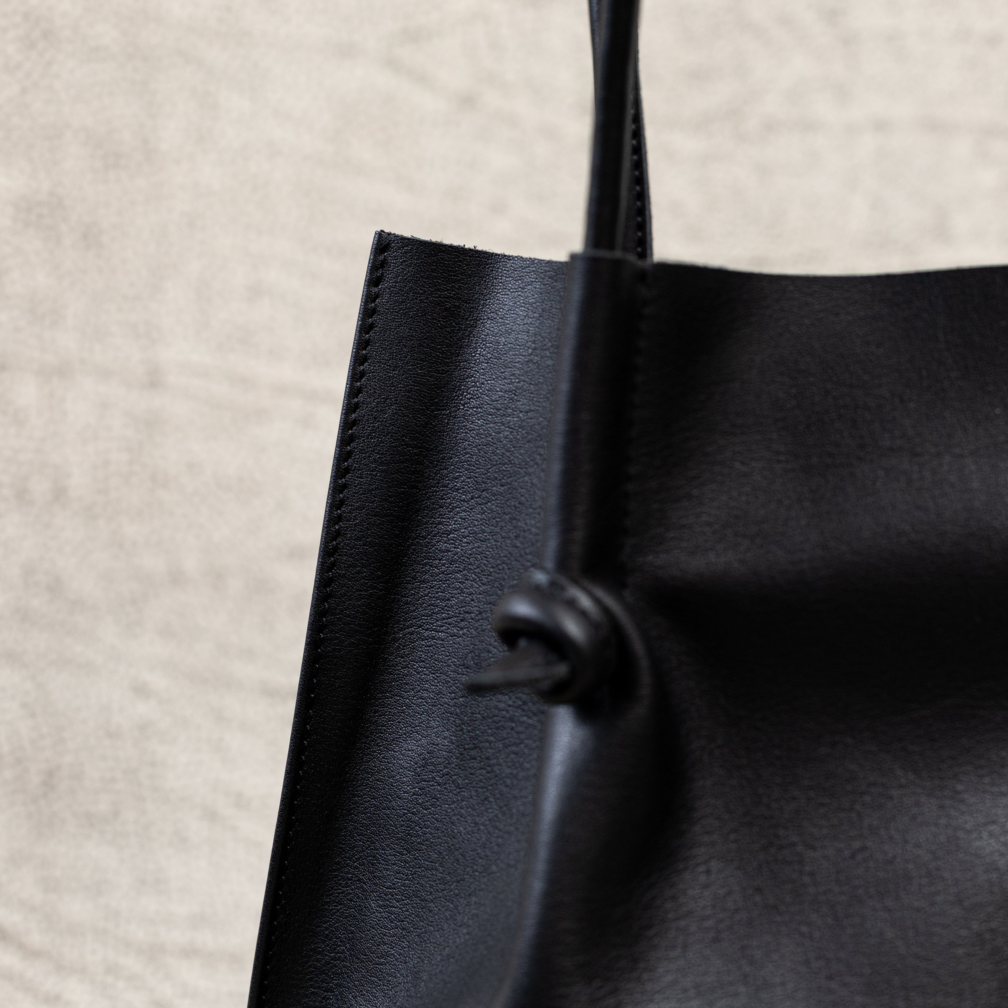 Flora Everyday Leather Tote in Smooth Calf Black with suede interior, rolled handles, and hand-finished edges—crafted for everyday elegance and ease.