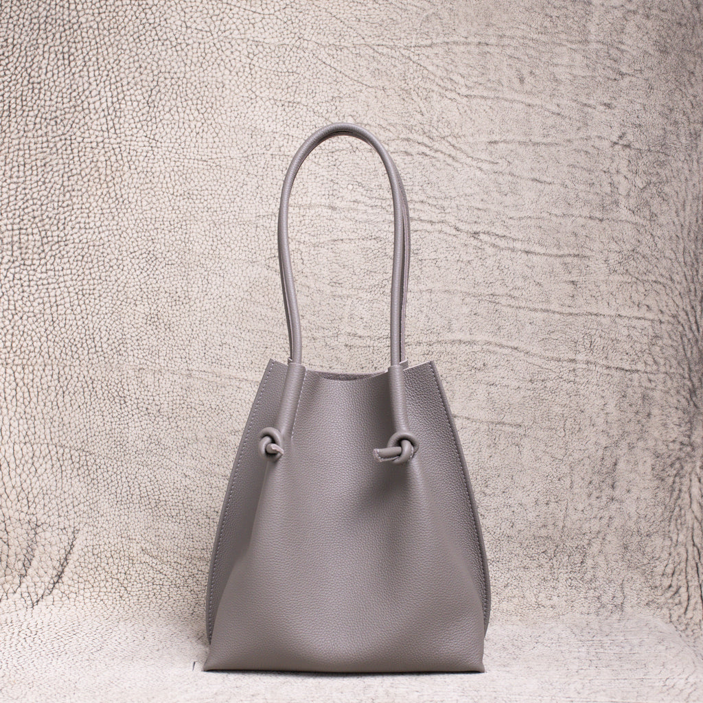 Front-facing view of the Flora Everyday Tote in Togo Gris, showing its softly structured form and knotted leather handles.