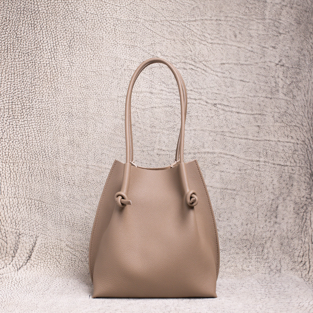 Front view of the Flora Tote in Togo Etoupe leather, displaying its structured silhouette and soft pebbled texture.