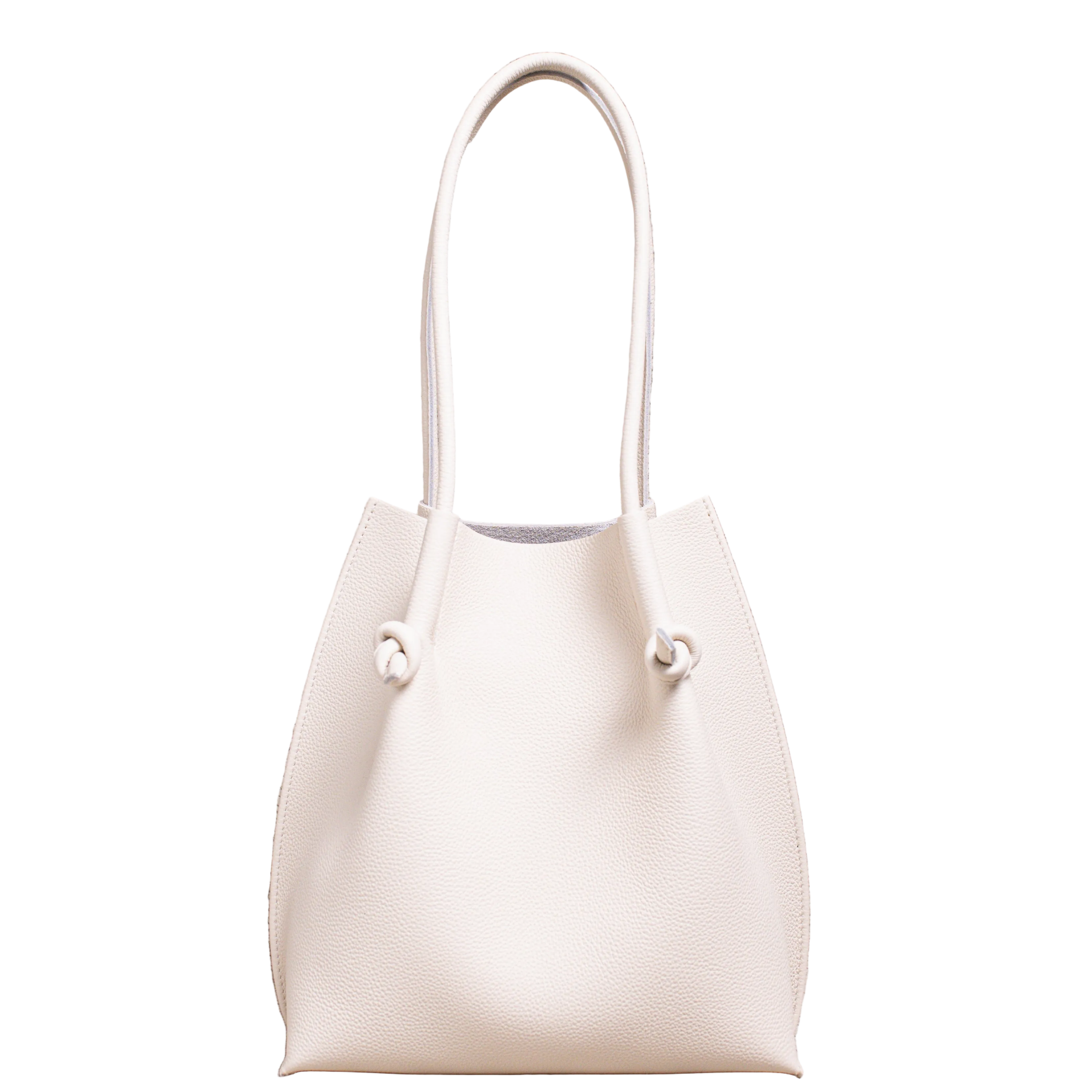 Flora Everyday Leather Tote in Togo Calf Beige, front view on white background. Structured bucket-style tote with tall rolled leather handles and two knotted leather ties cinching the open top.