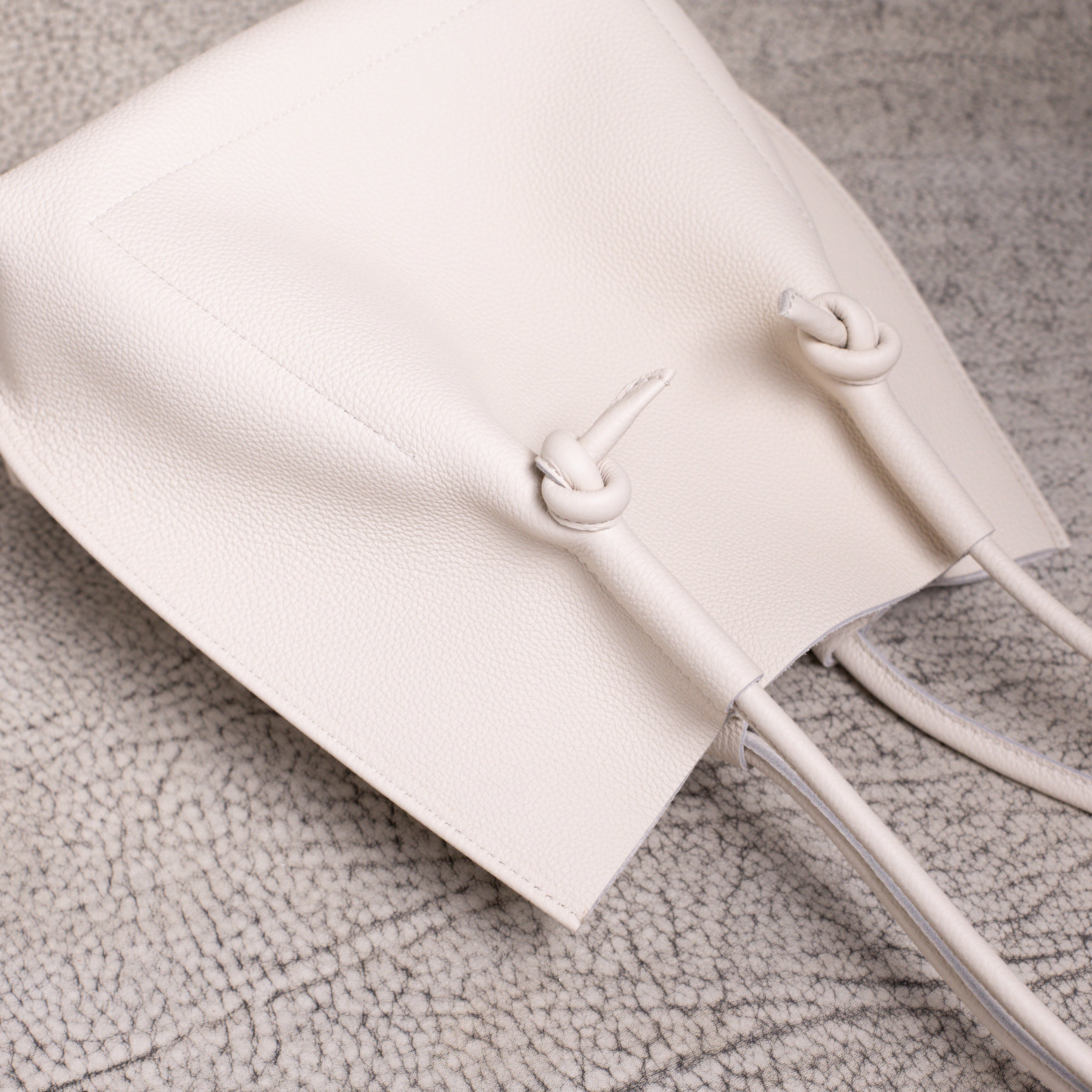 Overhead close-up showing the knotted handle design and subtle grain of the Beige Togo leather.