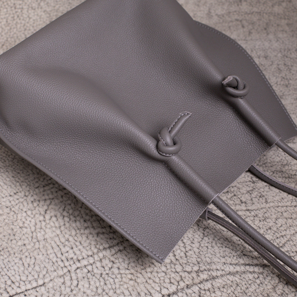 Flat lay from above showing the relaxed shape of the Flora tote, with the handles and knotted design resting naturally.
