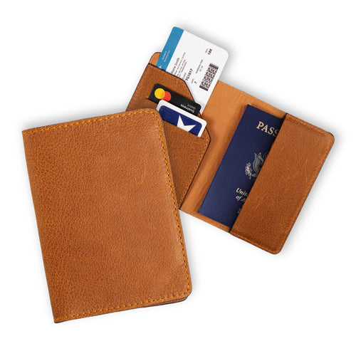 Two cinnamon tan leather passport wallets on white: one closed showing the warm pebbled exterior, one open with diagonal card pocket holding two cards and a boarding pass on the left, and a U.S. passport inserted on the right. Warm amber lining and golden yellow stitching throughout.