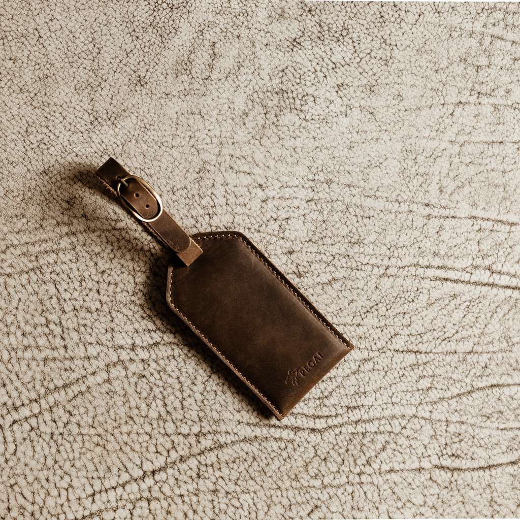 Rich brown full-grain leather luggage tag with brass buckle, perfect for gifting or upgrading your travel essentials.