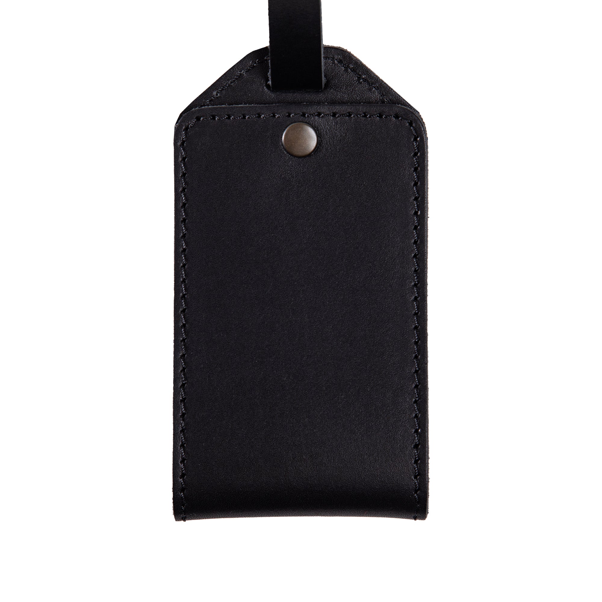 Close-up of black full-grain leather luggage tag with snap closure and fine stitching