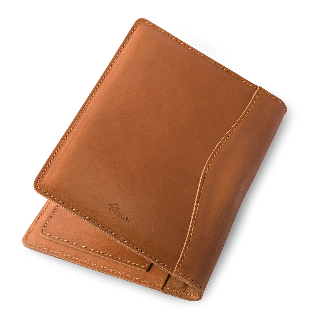 PEGAI Eriksen Jr. padfolio in cognac brown Zurich calfskin, angled closed view showing the curved seam stitching and embossed PEGAI pegasus logo on the cover.