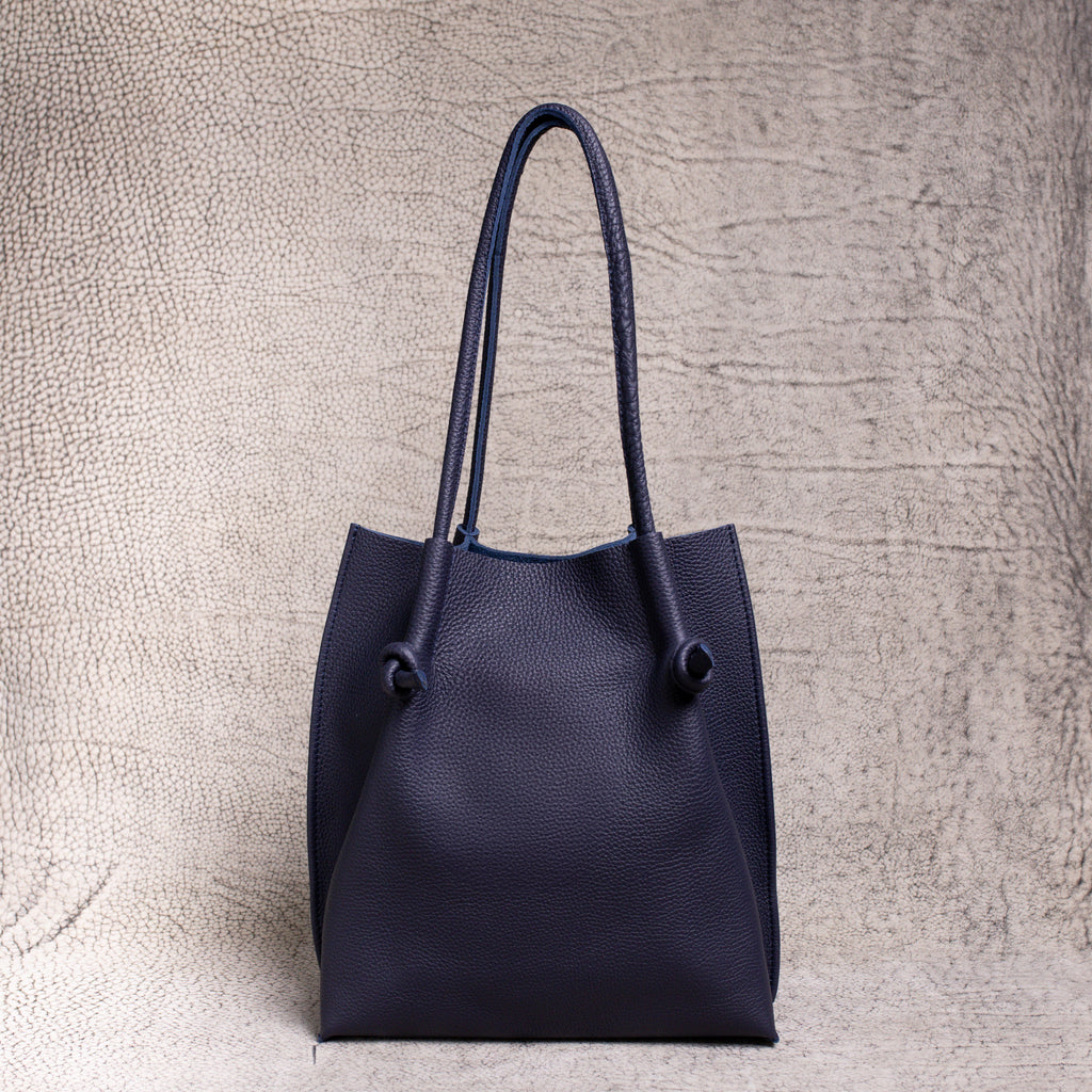 Full frontal shot of the Flora Tote in Togo Blue. Clean silhouette, dual rolled handles, and soft structure express timeless, understated luxury.