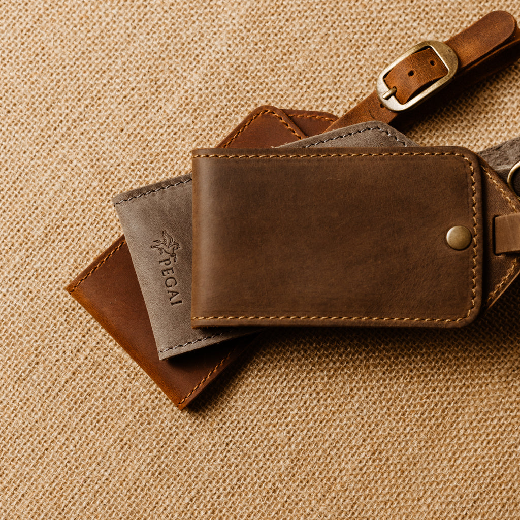 Collection of handcrafted leather luggage tags in brown and grey leather with antique brass hardware