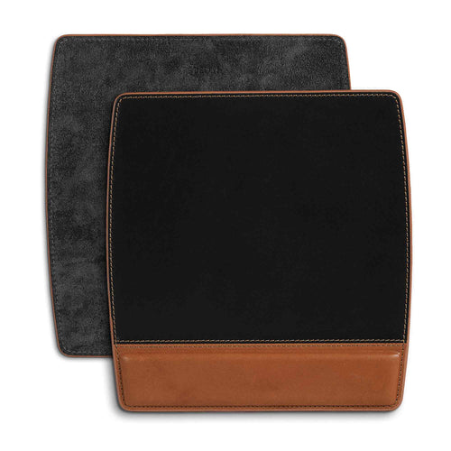 Two Bumpy Leather Mouse Pads in Maui Charcoal Black stacked slightly offset on a white surface, showing both sides. Front pad displays the two-tone design: matte black suede upper surface and a warm cognac tan full-grain leather wrist rest panel along the bottom, finished with contrast saddle stitching. Rear pad shows the charcoal black suede backing with debossed PEGAI logo stamp near the top edge.