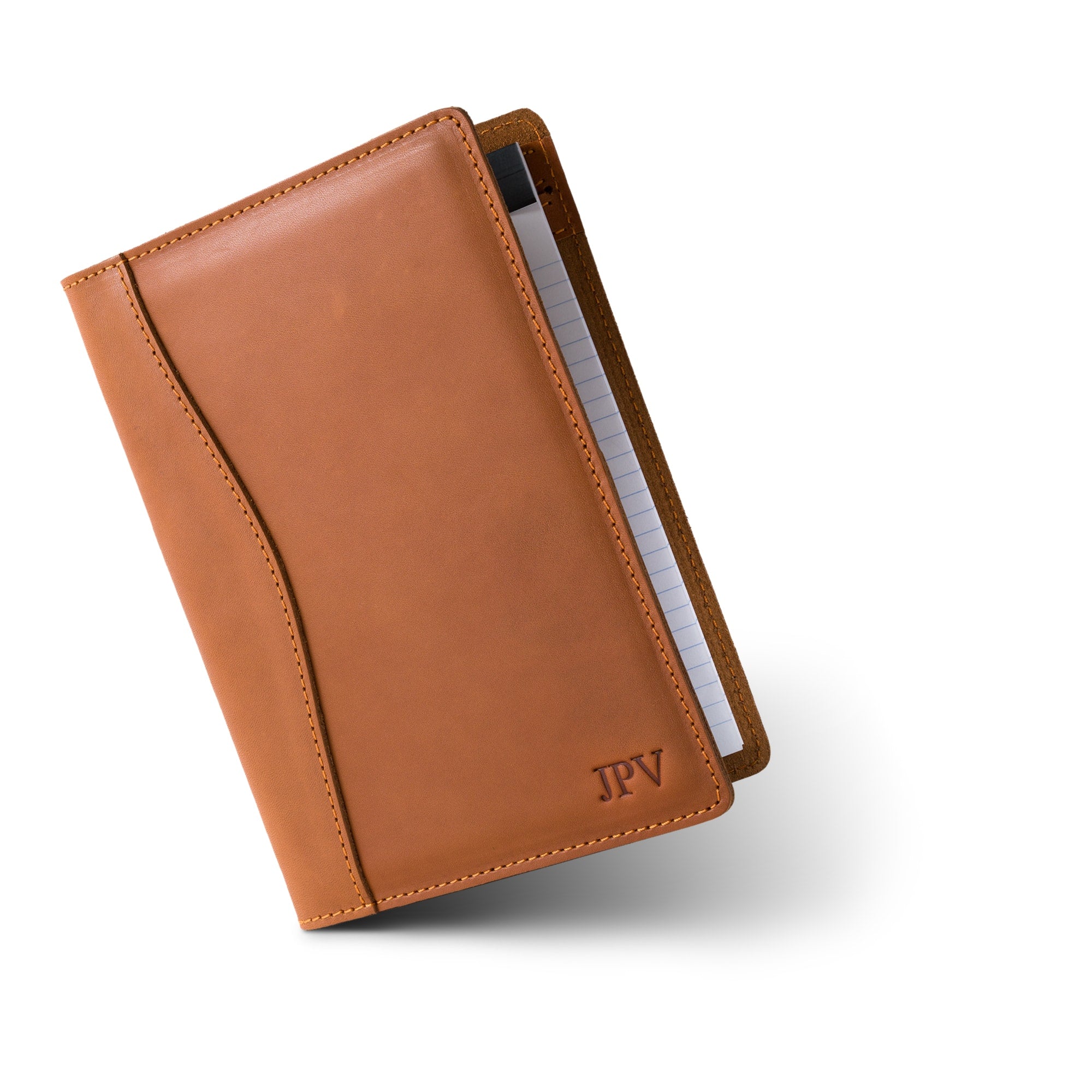 PEGAI Eriksen Jr. padfolio in cognac brown Zurich calfskin, standing closed at an angle with a lined legal pad tucked inside and embossed "JPV" monogram on the cover. 