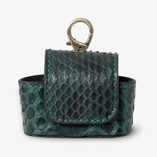Coil AirPods case in Jungle python leather, front view. Deep emerald and black scales with visible teal hand-stitching detail. Magnetic flap closure and antique brass keychain clip at top. Black interior visible.